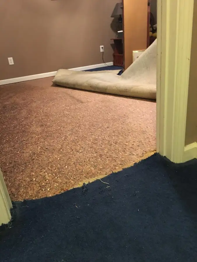 Carpet pad removal revealing water damage during Water Mitigation Services in Lancaster